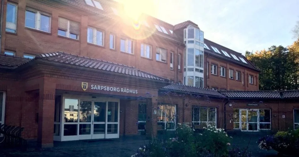 The entrance to Sarpsborg town hall, a red brick building, in evening sun